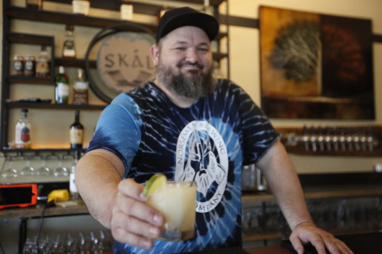 Chad Royer, kitchen manager at Norseman Brewing Lakeheim, serves a Lime in the Coconut drink Wednesday afternoon. Lime in the Coconut is a popular cocktail menu item at the bar.