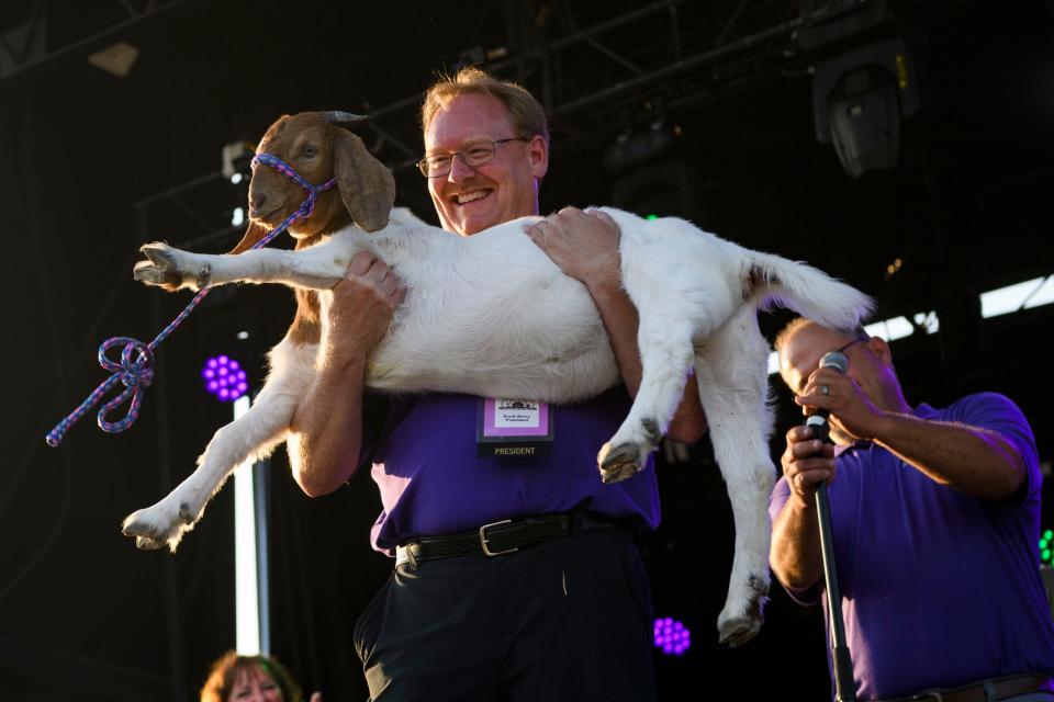 Vanderburgh County Fair President Scott Berry holds up a goat named Diet Dr. Pepper Cherry Sundae after being gifted it as a joke during the kick-off ceremony for the 100th Vanderburgh County Fair held at the 4-H Center in Evansville, Ind., Monday evening, July 26, 2021. The fair board surprised him by calling him the GOAT – Greatest of All Time – president before handing him the goat on stage. 