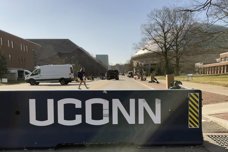 A street is blocked at at UConn in Storrs, Conn., Tuesday, April 4, 2023. Thousands of UConn fans, most of them students, spilled onto campus after watching a broadcast of the Huskies’ NCAA Tournament win over San Diego State, Monday night, with some pulling down signs and light poles, smashing windows and causing other damage. Gampel Pavilion, rear right, was open Monday night for students to watch the game, which was played in Houston. (AP Photo/Pat Eaton-Robb)