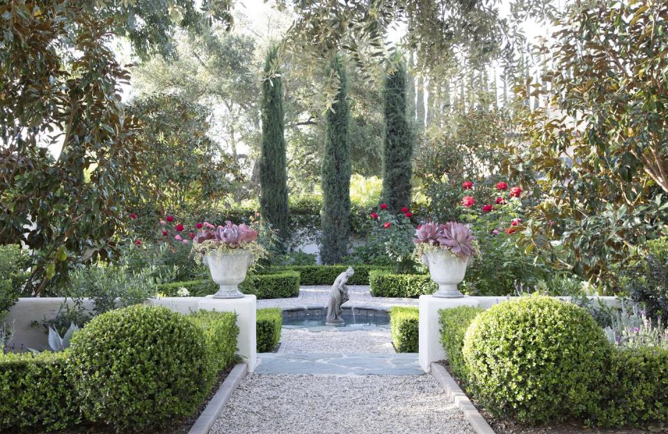 a garden with a statue in the center