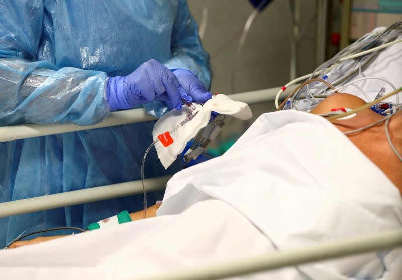 FILE PHOTO: A medical worker takes care of a patient infected with COVID-19 at the intensive care unit (ICU) of the Infanta Sofia University hospital in Spain