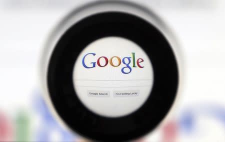 A Google search page is seen through a magnifying glass in this photo illustration taken in Brussels May 30, 2014. REUTERS/Francois Lenoir