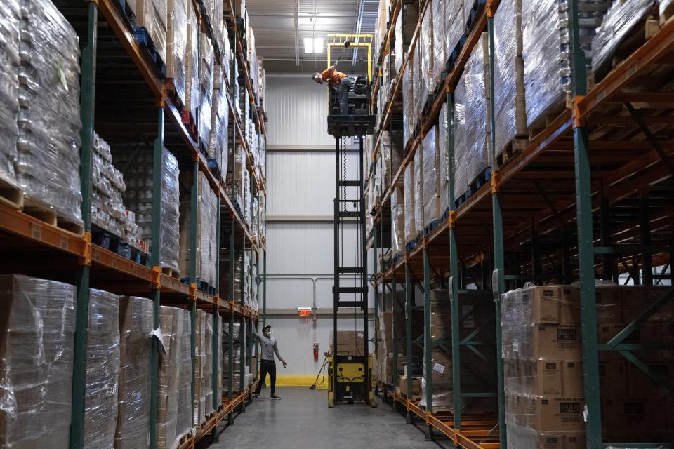 Workers shout to each other from five levels of stored food items at the warehouse of The Capital Area Food Bank, Tuesday, Oct. 5, 2021, in Washington. (AP Photo/Jacquelyn Martin)