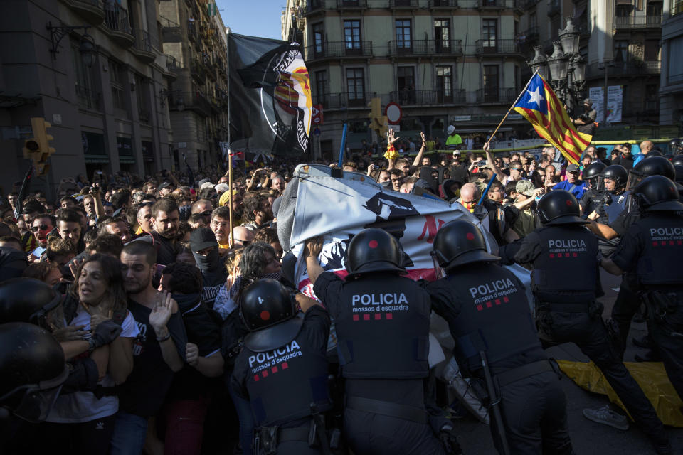 Catalan police officers clash with pro independence demonstrators on their way to meet demonstrations by members and supporters of National Police and Guardia Civil in Barcelona on Saturday, Sept. 29, 2018. (AP Photo/Emilio Morenatti)