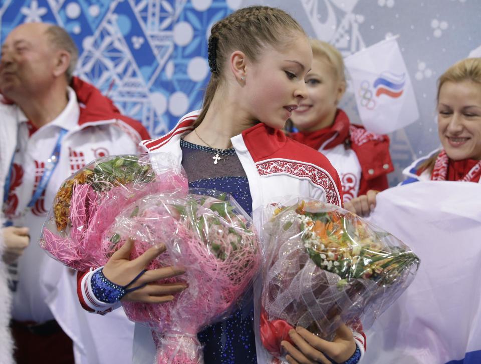 Yulia Lipnitskaya of Russia holds flowers given to her by spectators after competing in the women's team short program figure skating competition at the Iceberg Skating Palace during the 2014 Winter Olympics, Saturday, Feb. 8, 2014, in Sochi, Russia. (AP Photo/Darron Cummings, Pool)