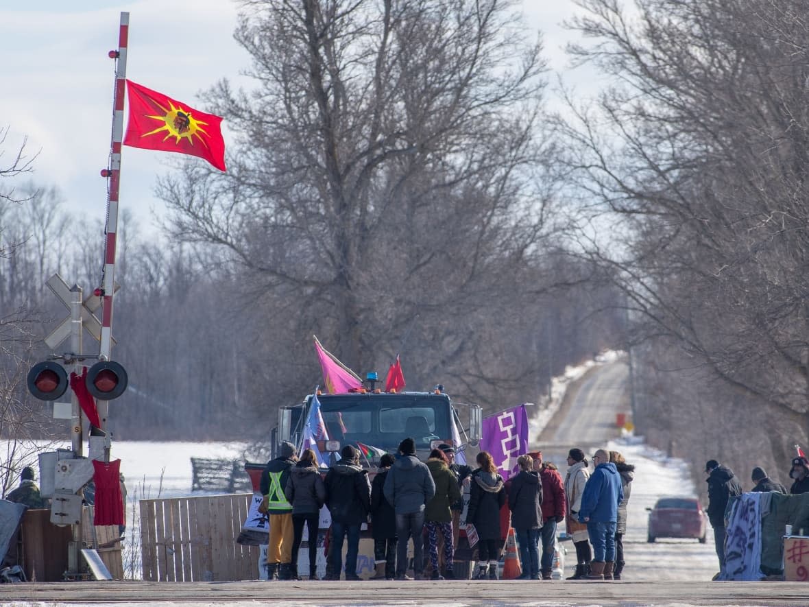 Supporters stand with protesters during a rail blockade in Ontario in 2020. Amid ongoing protests around Canada, Indigenous leaders are speaking out against how authorities are reacting to different parties. (Lars Hagberg/The Canadian Press - image credit)