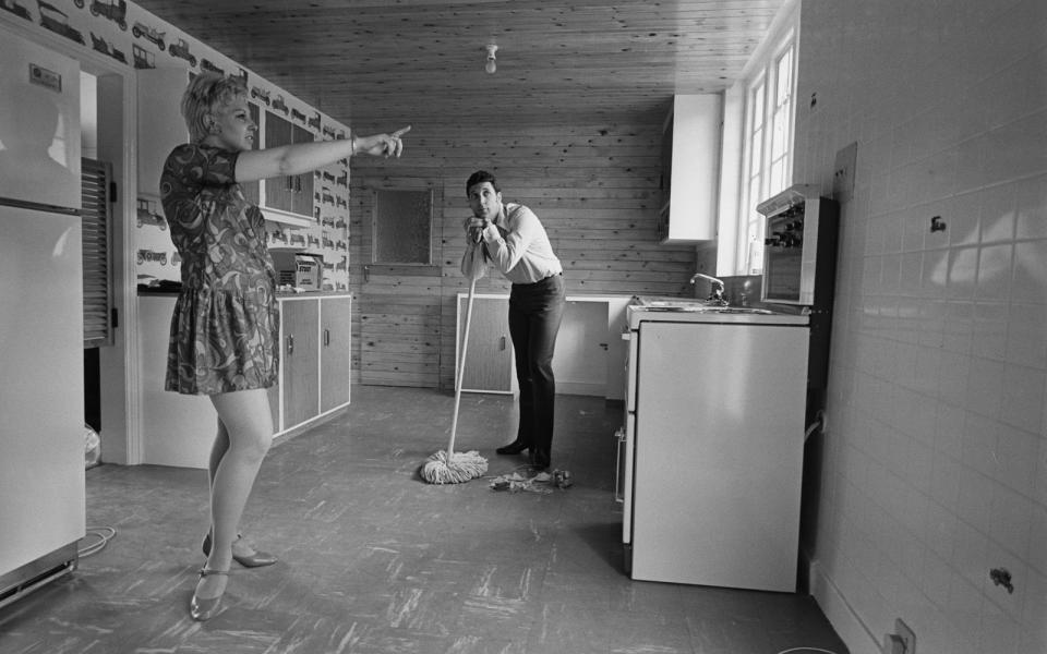 "Da vorne musst du noch wischen und bitte nicht die Wandfliesen vergessen": Stubentiger Tom Jones mit Ehefrau Linda 1967 in ihrem Haus in Sudbury in der englischen Grafschaft Suffolk. (Bild: Getty Images/Len Trievnor/Hulton Archive/Express)