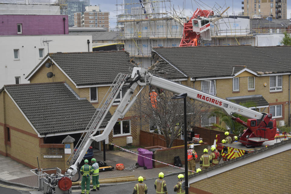 The scene in Bow where a 20-metre crane collapsed on to a property leaving people trapped inside, in east London, Wednesday July 8, 2020. The London Fire Brigade says a 20-meter crane has collapsed onto a block of apartments under development and two houses in east London. The brigade’s Assistant Commissioner Graham Ellis says urban search and rescue crews are undertaking “a complex rescue operation” and using specialized equipment to search the properties on Wednesday. (Victoria Jones/PA via AP)