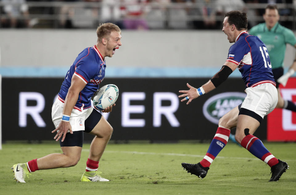 Russia's Kirill Golosnitskiy, left, celebrates with teammate Vasily Artemyev after scoring a try during the Rugby World Cup Pool A game at Tokyo Stadium between Russia and Japan in Tokyo, Japan, Friday, Sept. 20, 2019. (AP Photo/Jae Hong)