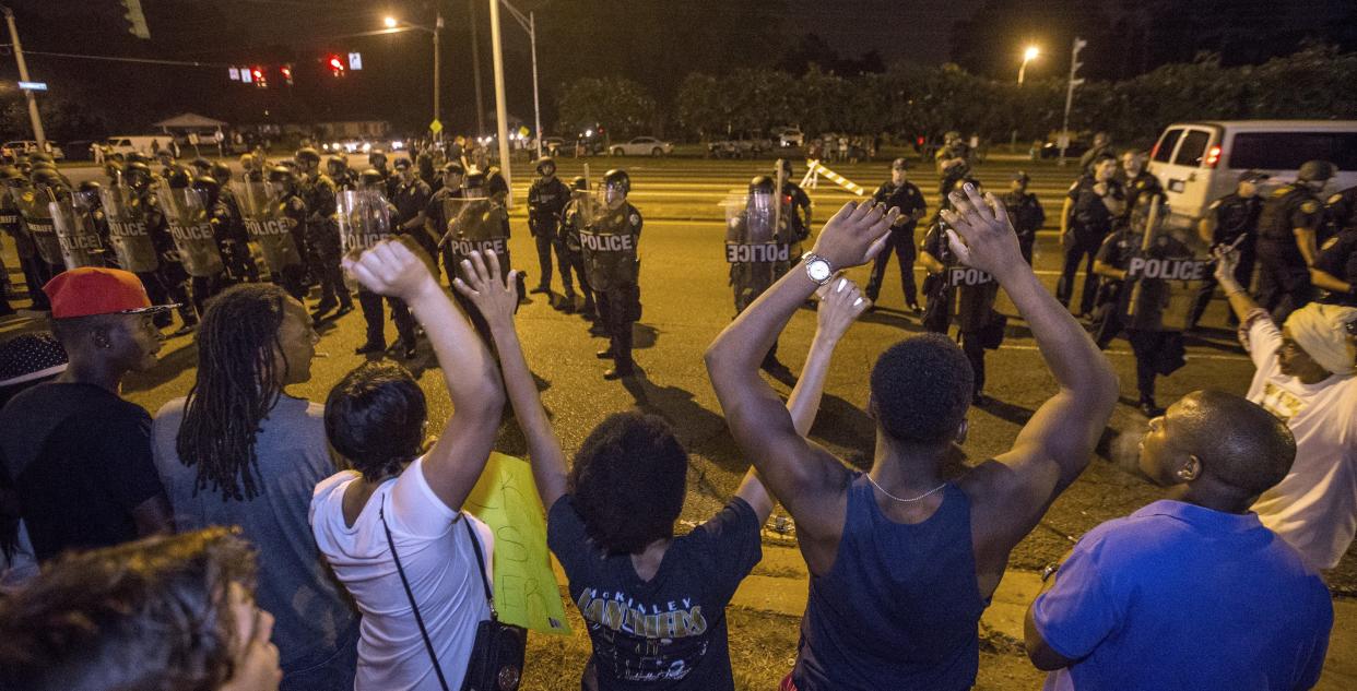 BATON ROUGE, LA -JULY 10: Protesters shout 'Hands up, don't shoot' as law enforcement gather before charging the protesters to make arrests on July 10, 2016 in Baton Rouge, Louisiana. Alton Sterling was shot by a police officer in front of the Triple S Food Mart in Baton Rouge on July 5th, leading the Department of Justice to open a civil rights investigation. (Photo by Mark Wallheiser/Getty Images)