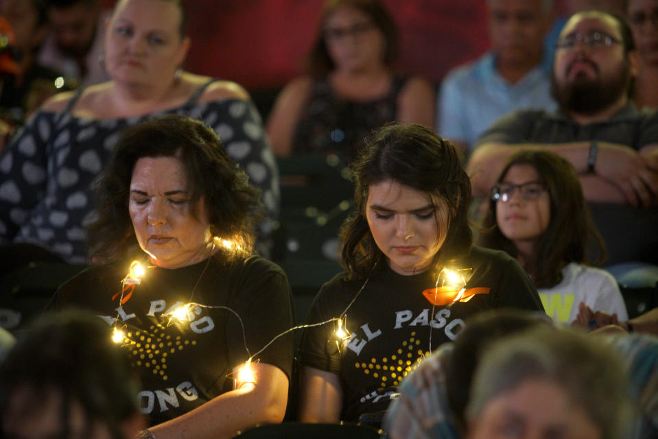 People bow their heads in prayer while attending a community memorial service, Wednesday, Aug. 14, 2019, at Southwest University Park, in El Paso, Texas, for those killed in a mass shooting on Aug. 3. (AP Photo/Jorge Salgado)