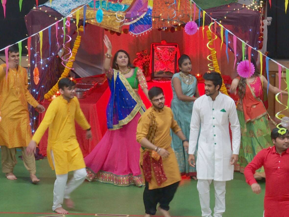 During Navratri, many Hindus participate in Garba, a traditional dance regional to the Indian province of Gujarat that involves large groups of people clad in cultural clothing dancing in circles around a statue of Durga. (Travis Kingdon/CBC - image credit)