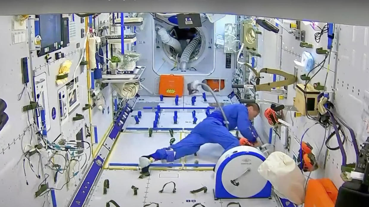  A Shenzhou 16 astronaut vacuums on board China's Tiangong space station. 