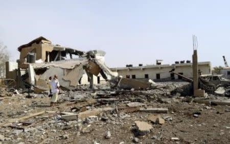 People walk at the site of a Saudi-led air strike targeting a marine biological farm at the al-Luhayyah area in Yemen's western city of Hodeidah October 10, 2015. REUTERS/Stringer