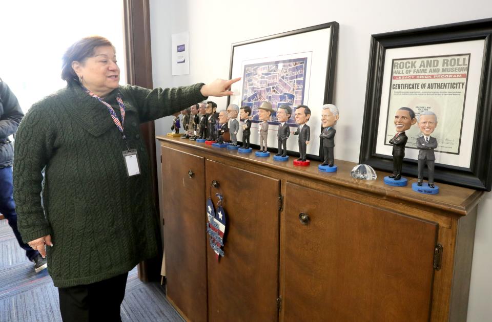 State & Federal Communications President & CEO Elizabeth Bartz talks about an Elizabeth Dole photograph along with her collection of presidential bobble heads outside her office Tuesday in Akron.