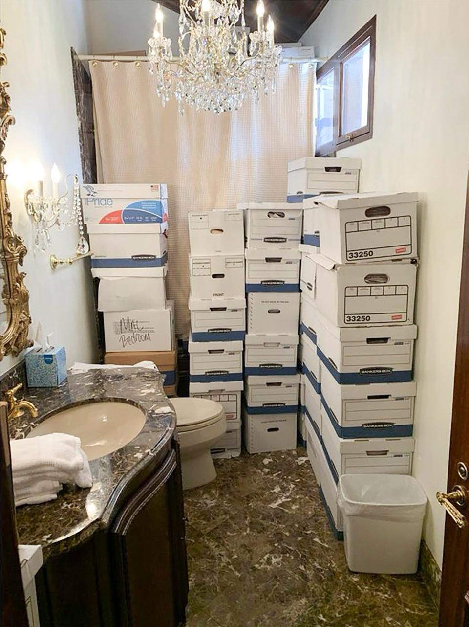 A photo provided by the Justice Department, and included in the unsealed indictment of former President Donald Trump, shows document boxes in a bathroom and shower in the Lake Room at Mar-a-Lago.