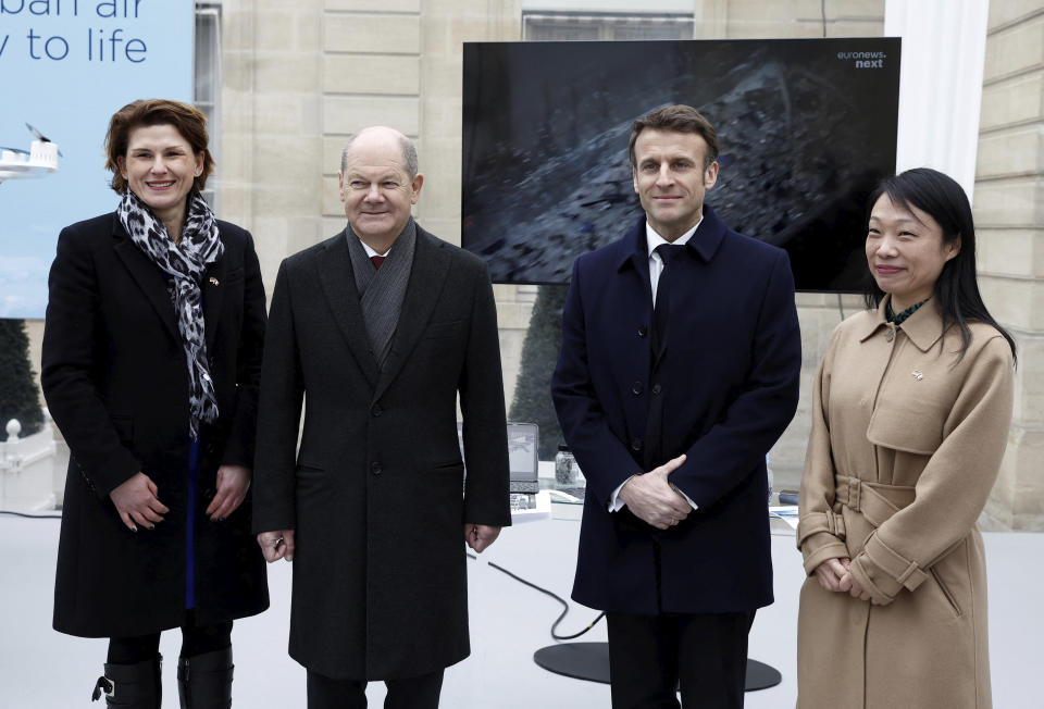 German Chancellor Olaf Scholz, second left, and French President Emmanuel Macron pose with Yun Luo, CEO of ROSI Solar, right, and Doris Birkhofer, president of Siemens France, during the the presentation of Franco-German industrial projects, Sunday, Jan. 22, 2023 at the Elysee Palace in Paris. France and Germany are seeking to overcome differences laid bare by Russia's war in Ukraine and shore up their alliance with a day of ceremonies and talks Sunday on Europe's security, energy and other challenges. (Benoit Tessier, Pool via AP)