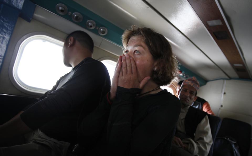 In this Friday, May 24, 2013 photo, a passenger reacts during turbulence as her flight approaches Lukla, Nepal. Carved out of the side of a mountain, the airport was built by Sir Edmund Hillary in 1965, and at an altitude of 2,843 meters (9,325 feet) it has earned the reputation of being one of the most extreme and dangerous airports in the world. (AP Photo/Niranjan Shrestha)