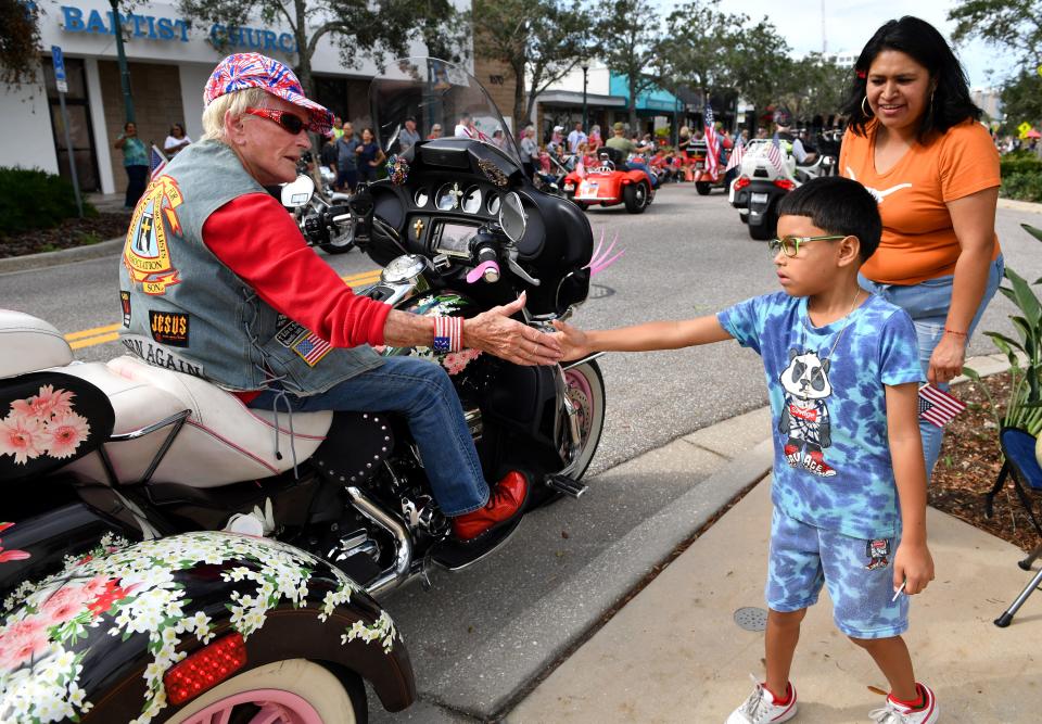 Jay Escobar-Lopez, 6, from Sarasota, gets a high-five from a participant in the annual Veterans Day Parade on Main St. in downtown Sarasota on Friday, Nov. 11, 2022. Escobar-Lopez had never been to a Veterans Day Parade before.  