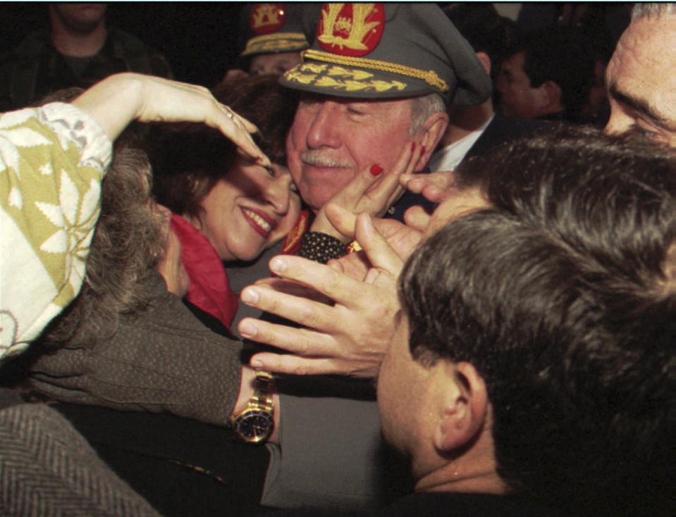 FILE - Former Chilean dictator and then-military commander Gen. Augusto Pinochet is embraced by a supporter as he meets with supporters who gathered at his home to greet him on the occasion of the 22nd anniversary of his taking the post as head of the Chilean armed forces, in Santiago, Chile, Aug. 23, 1995. As Chile marks the 50th anniversary Monday, Sept. 11, 2023 of the coup that brought Pinochet to power, polling shows more than one-third of Chileans today justify the military takeover of a democratically elected government that went on to violate human rights, murder opponents, cancel elections, restrict the media, suppress labor unions and disband political parties. (AP Photo/Santiago Llanquin, FILE)