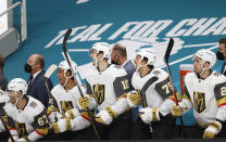 Vegas Golden Knights left wing Max Pacioretty (67), right wing Keegan Kolesar (55), center Nicolas Roy (10), right wing Ryan Reaves (75) and left wing William Carrier (28) react on the bench after center Jonathan Marchessault (not shown) scored against the San Jose Sharks during the first period of an NHL hockey game in San Jose, Calif., Saturday, Feb. 13, 2021. (AP Photo/Josie Lepe)