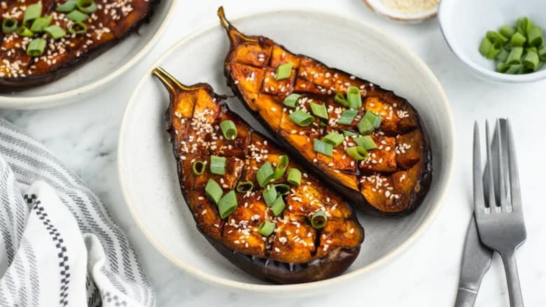 Glazed eggplant halves in white bowl