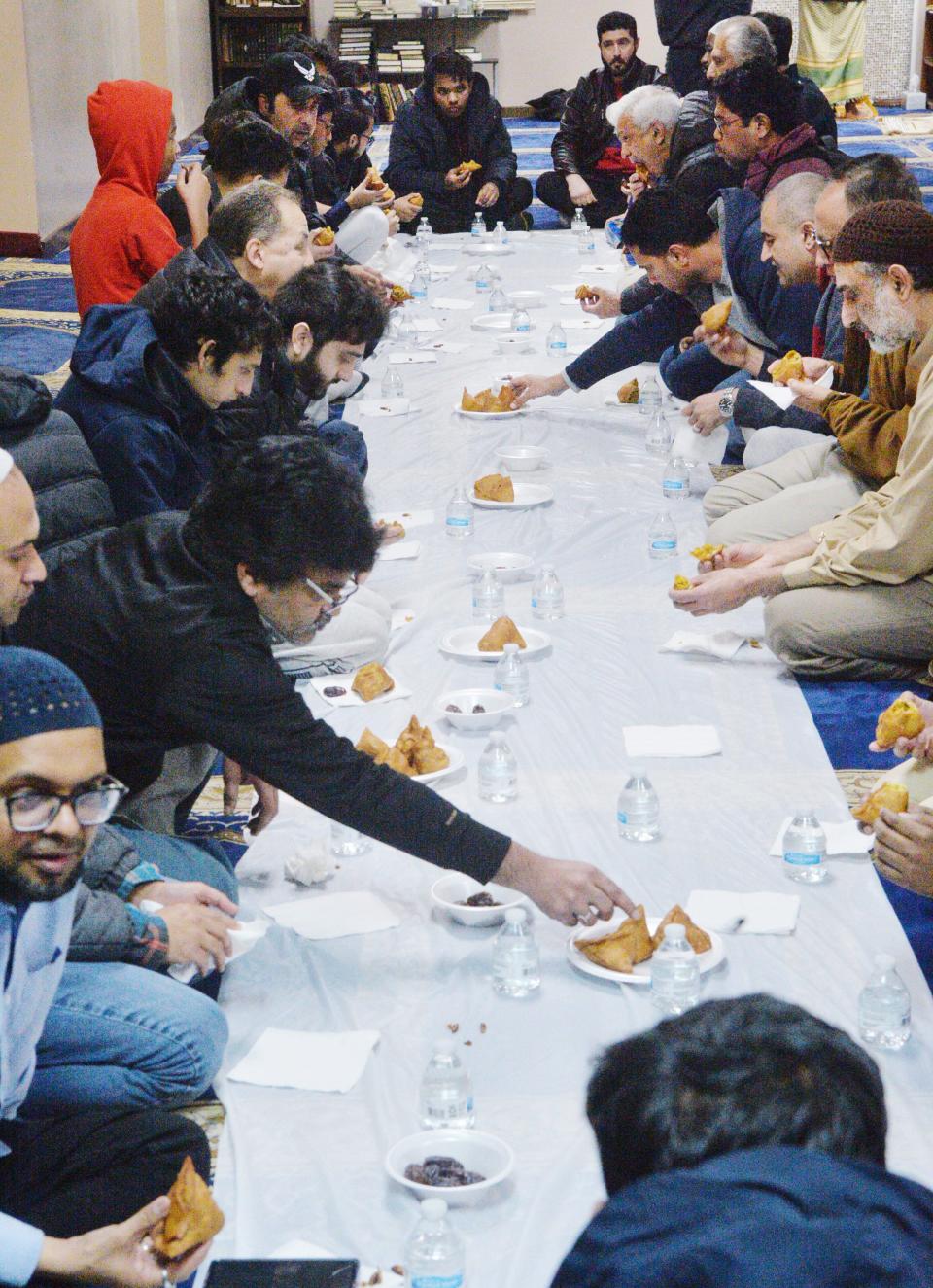 Men begin to eat to observe the iftar, or breakfast breaking the daily fast during Ramadan, at the Erie Masjid on April 1, 2023. Those of the Muslim faith fast from sunrise to sunset during Ramadan, which began on March 22 and ends on April 21. Women in the Masjid were eating in a separate area of the building.
