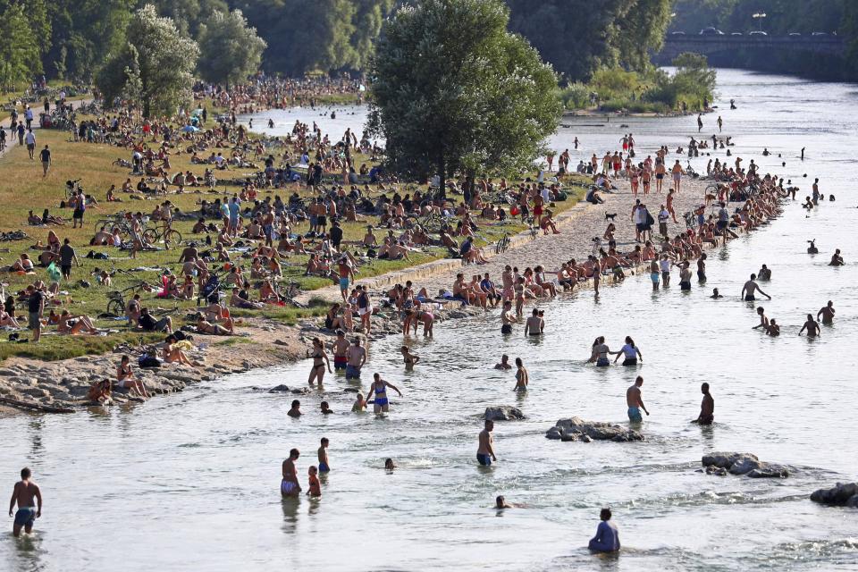 FILE - In this July 25, 2019 file photo people enjoy the hot summer weather at the river Isar in Munich, Germany. The world could see average global temperatures 1.5 degrees Celsius (2.7 Fahrenheit) above the pre-industrial average for the first time in the coming five years, the U.N. weather agency said Thursday. The 1.5-C mark is a key threshold that countries have agreed to limit global warming to, if possible. Scientists say average temperatures around the world are already at least 1 C higher now than during the period from 1850-1900 because of man-made greenhouse emissions. (AP Photo/Matthias Schrader, File)