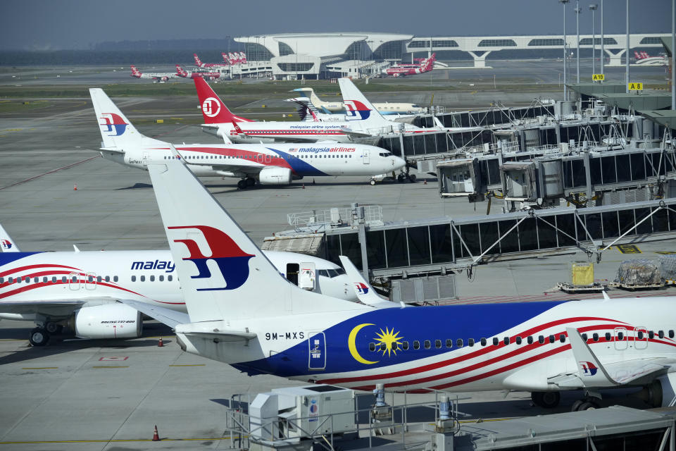 Malaysia Airlines planes taxi at terminal while uploading passengers at Kuala Lumpur International Airport in Sepang, Malaysia, Friday, April 1, 2022. Malaysia's international borders open to foreigners on Friday, and fully vaccinated travelers do not have to undergo quarantine. (AP Photo/Vincent Thian)