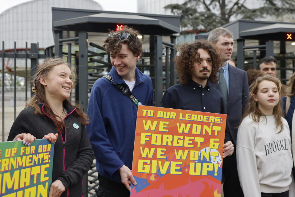 Swedish climate activist Greta Thunberg, left, joins youths from Portugal during a demonstration outside the European Court of Human Rights Tuesday, April 9, 2024 in Strasbourg, eastern France. Europe's highest human rights court will rule Tuesday on a group of landmark climate change cases aimed at forcing countries to meet international obligations to reduce greenhouse gas emissions. The European Court of Human Rights will hand down decisions in a trio of cases brought by a French mayor, six Portuguese youngsters and more than 2,000 elderly Swiss women who say their governments are not doing enough to combat climate change. (AP Photo/Jean-Francois Badias)