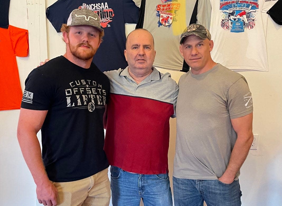 Strong and Courageous Wrestling Club coach Norman Osteen, center, poses with his first All-American, James Short (right) and his last All-American, Triston Norris. Short died on April 29 at the age of 49.