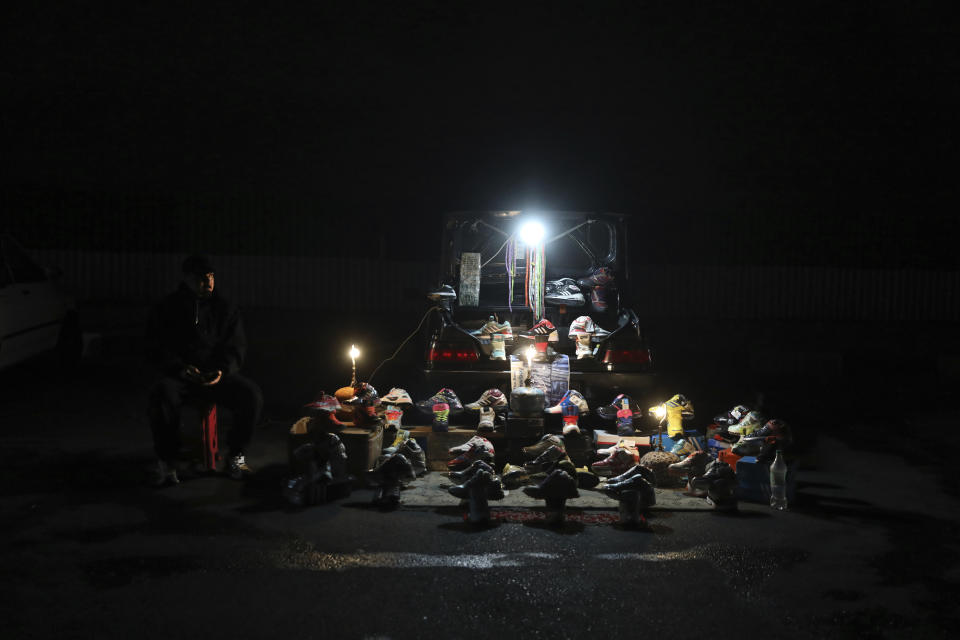 A street vendor waits for customer while selling shoes on the side of a highway in southwestern Tehran, Iran, Tuesday, Nov. 2, 2021. As U.S. sanctions and the coronavirus pandemic wreak havoc on Iran's economy, suicides in the country increased by over 4%, according to a government study cited by the reformist daily Etemad. About 1 million Iranians have lost their jobs, and unemployment has climbed over 10% — a rate that is nearly twice as big among youths. (AP Photo/Vahid Salemi)