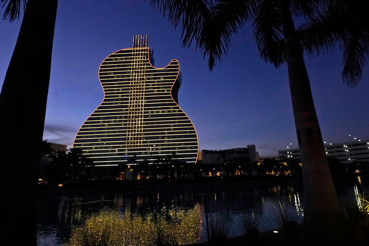 FILE- In this Jan. 19, 2021, file pot, The Guitar Hotel at Seminole Hard Rock Hotel & Casino Hollywood is illuminated at night in Hollywood, Fla. Florida Gov. Ron DeSantis reached an agreement with the state's Seminole Tribe on Friday, April 23, 2021, that would greatly expand gambling in the state, including the introduction of legalized sports wagering. (AP Photo/Wilfredo Lee)