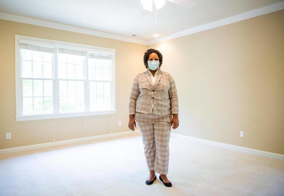 Real estate agent Camille Malcolm, of United Real Estate, stands for a portrait in the empty master bedroom of a home for sale, on Tuesday, April 27, 2021, in Durham, N.C.