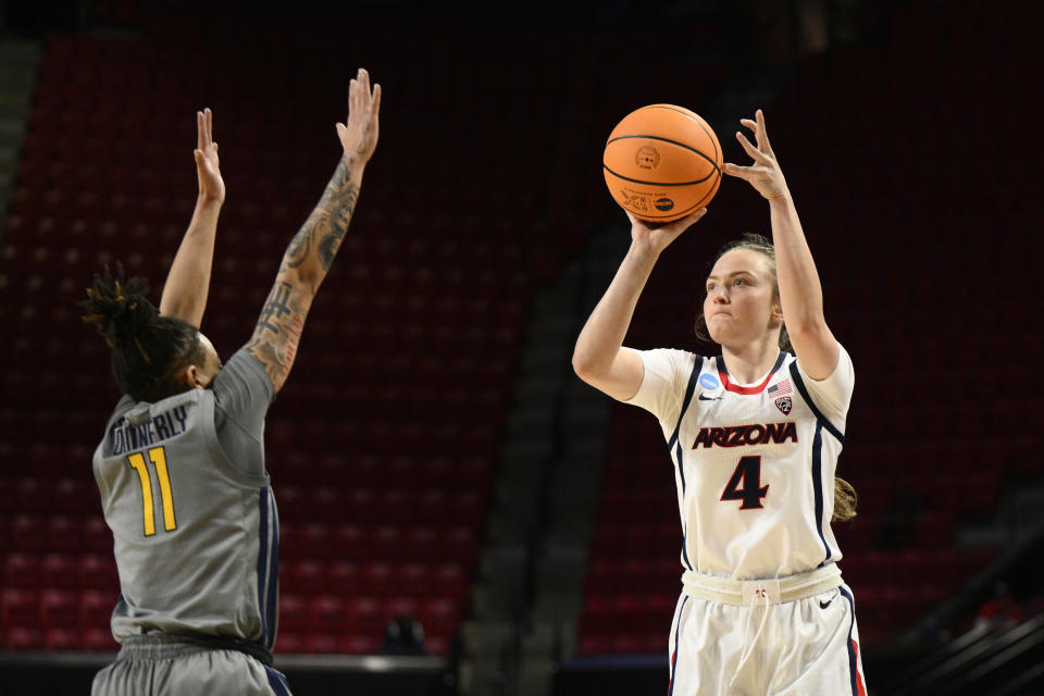 Arizona guard Madison Conner (4) shoots against West Virginia guard JJ Quinerly (11) in the first half of a first-round college basketball game in the NCAA Tournament, Friday, March 17, 2023, in College Park, Md. (AP Photo/Nick Wass)