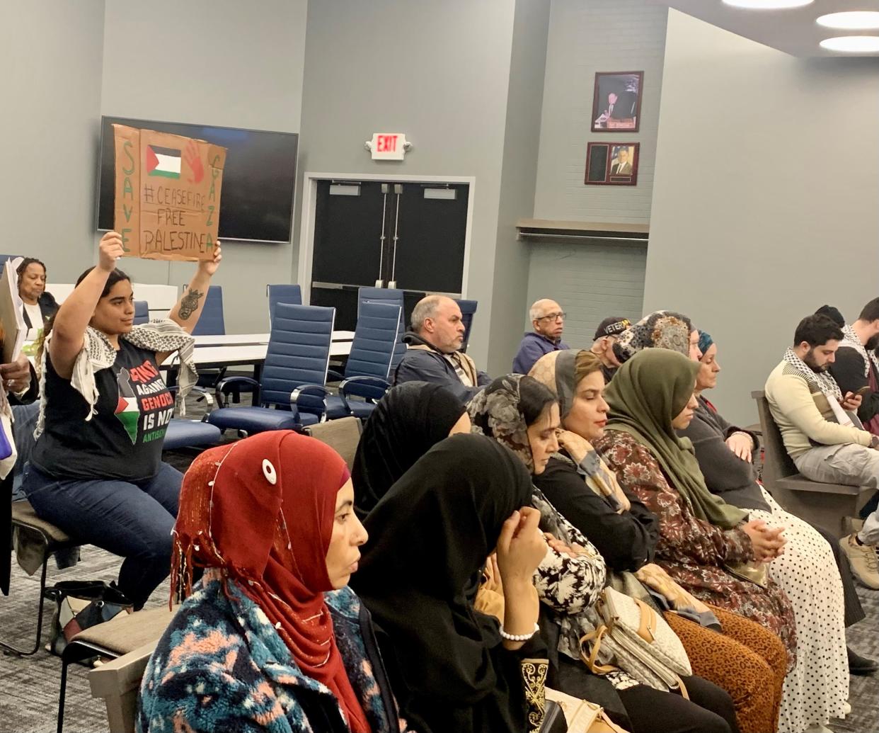 Isabel Juarez of Canton Township holds a sign calling for a cease-fire resolution in the Israel-Hamas war during Monday's Canton City Council meeting. An increasing number of Stark County residents have been attending the Canton Council meetings since mid-February to ask council to adopt a cease-fire resolution.