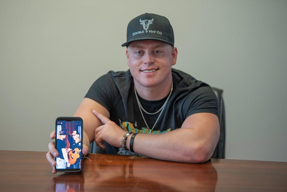 Cody Cozz shows a cell phone photo from an October 2020 meeting with country artist Craig Campbell.