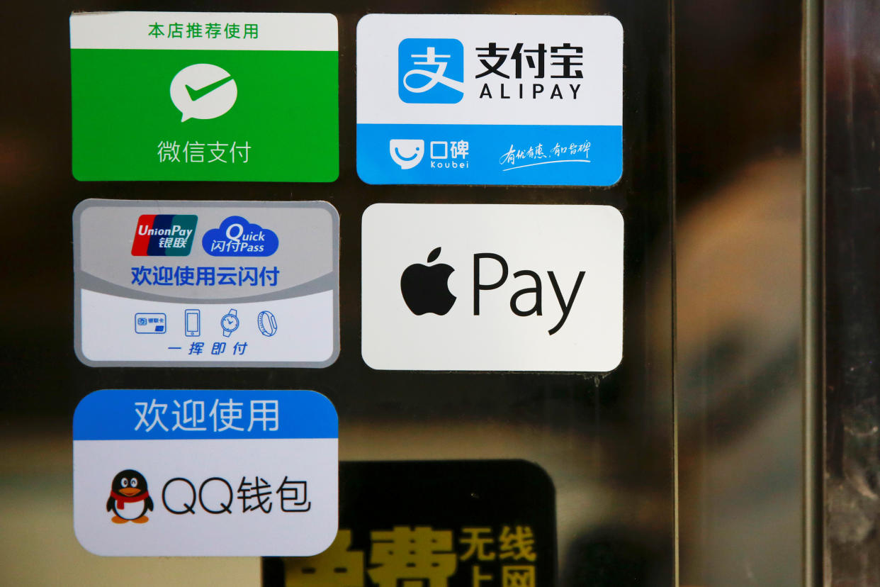 Paying method stickers on the doors of a restaurant at the Beijing Railway Station in central Beijing. REUTERS/Damir Sagolj