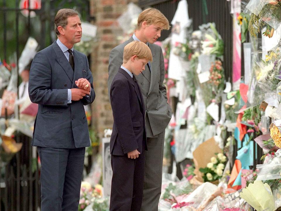 King Charles III, Prince William, and Prince Harry look at floral tributes for Princess Diana in 1997.