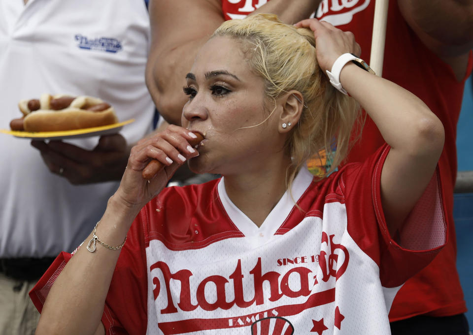 <p>US competitive eater Miki Sudo swallows hot dogs during the Women’s Nathan’s Famous Fourth of July International Hot-dog eating contest in Coney Island, New York on July 4, 2017. Sudo won by consuming 41 hotdogs. (Peter Foley/EPA/Shutterstock) </p>