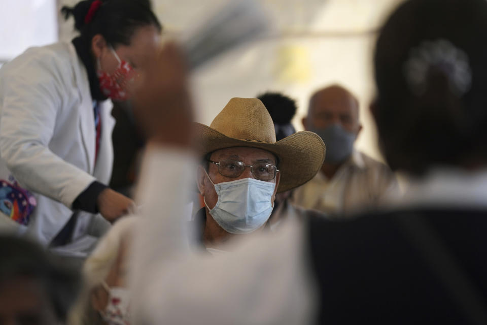 A man listens to an explanation about the booster against COVID-19 during a vaccination campaign for people 60 and over, in Mexico City, Tuesday, Jan. 4, 2022. (AP Photo/Fernando Llano)