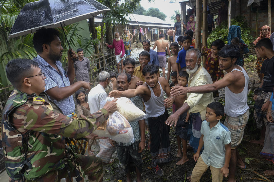 A Bangladeshi army soldier distributes relief material to flood affected people in Sylhet, Bangladesh, Wednesday, June 22, 2022. (AP Photo/Mahmud Hossain Opu)