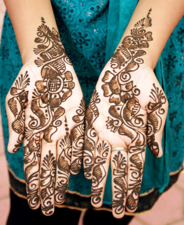 Girl with hands decorated with henna (mehendi).