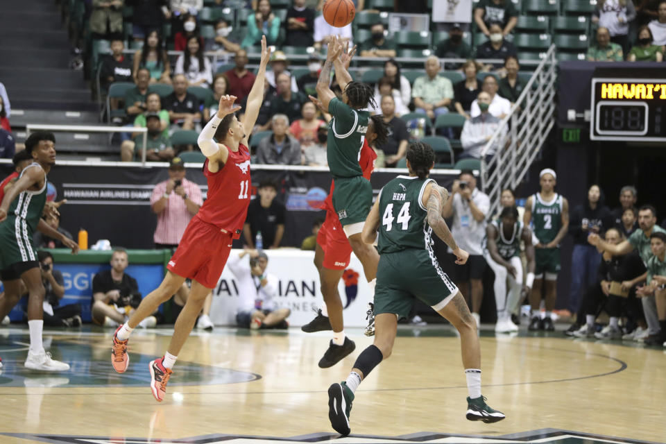 Hawaii guard JoVon McClanahan (3) makes a 3-point shot to put Hawaii ahead of SMU at the end of an NCAA college basketball game, Sunday Dec. 25, 2022, in Honolulu. Hawaii defeated SMU 58-57 to win the Diamond Head Classic tournament. (AP Photo/Marco Garcia)