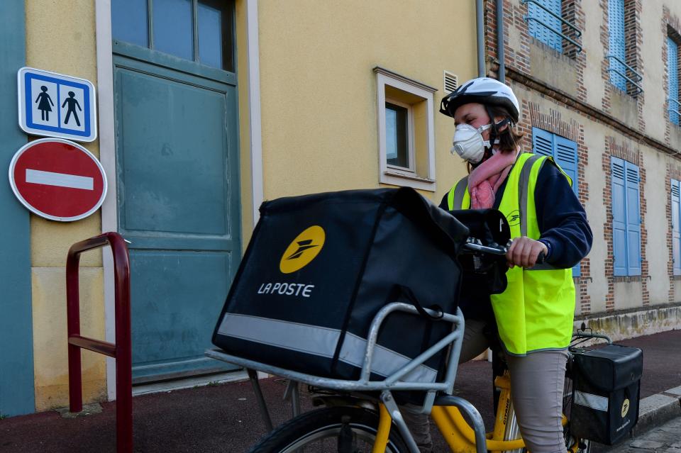 Postal workers have continued to deliver mail and packages throughout the pandemic. (Photo: JEAN-FRANCOIS MONIER/AFP via Getty Images)