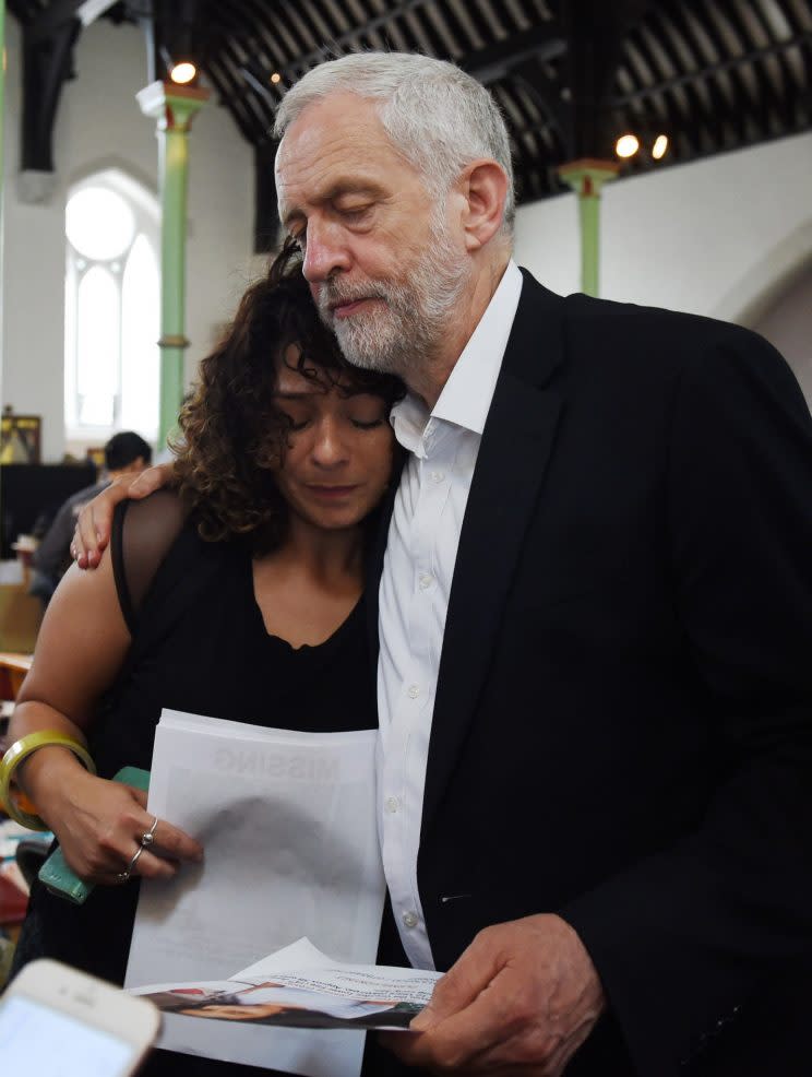 Labor leader Jeremy Corbyn comforts a local resident at St Clement’s Church in west London. (Photo: David Mirzoeff – WPA Pool/Getty Images)