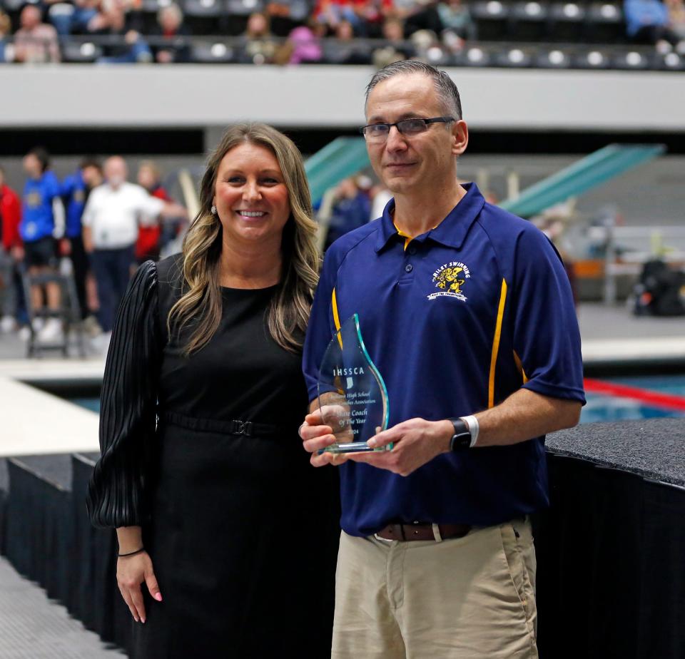 South Bend Riley swimming head coach John VanDriessche, right, takes a photo with IHSAA assistant commissioner Kerrie Rosati after being presented with the coach of the year award at the IHSAA boys swimming state championship meet Saturday, Feb. 24, 2024, at the IU Natatorium in Indianapolis.