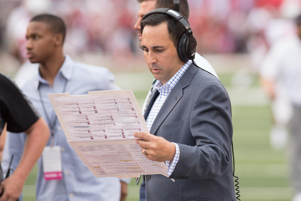 Joe Tessitore looks over his announcer's sheet with a headset on. 