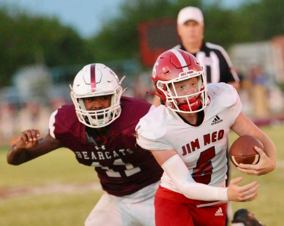 Jim Ned quarterback Grant Glidewell tries to run past Hawley's Diontay Ramon on Aug. 26 in Hawley.