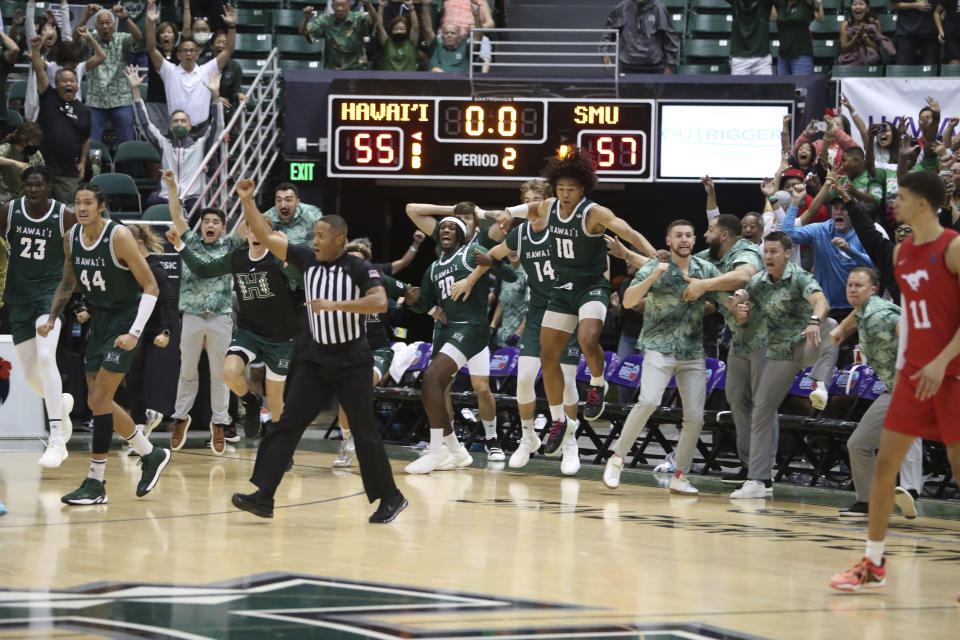 The Hawaii bench reacts after guard JoVon McClanahan (3) makes a 3-point shot to put Hawaii ahead of SMU at the end of an NCAA college basketball game, Sunday, Dec. 25, 2022, in Honolulu. Hawaii defeated SMU 58-57 to win the Diamond Head Classic tournament. (AP Photo/Marco Garcia)